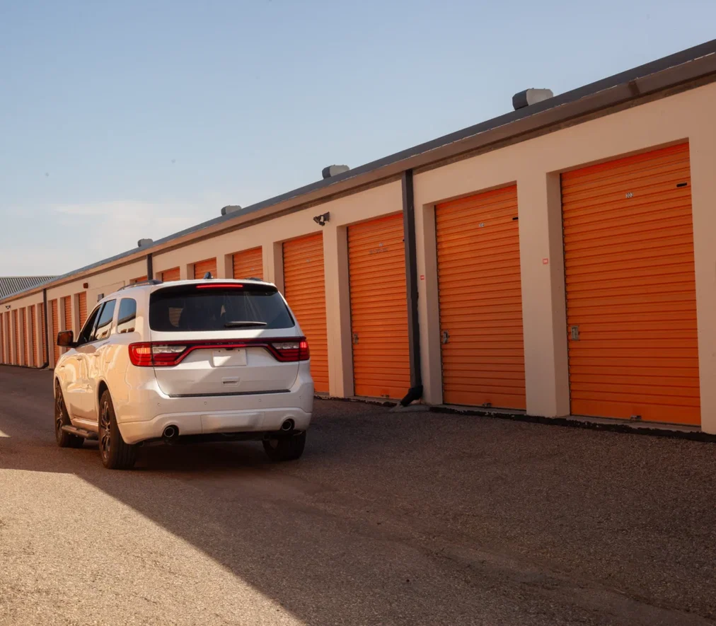Orange roll-up doors on a row of drive-up storage units