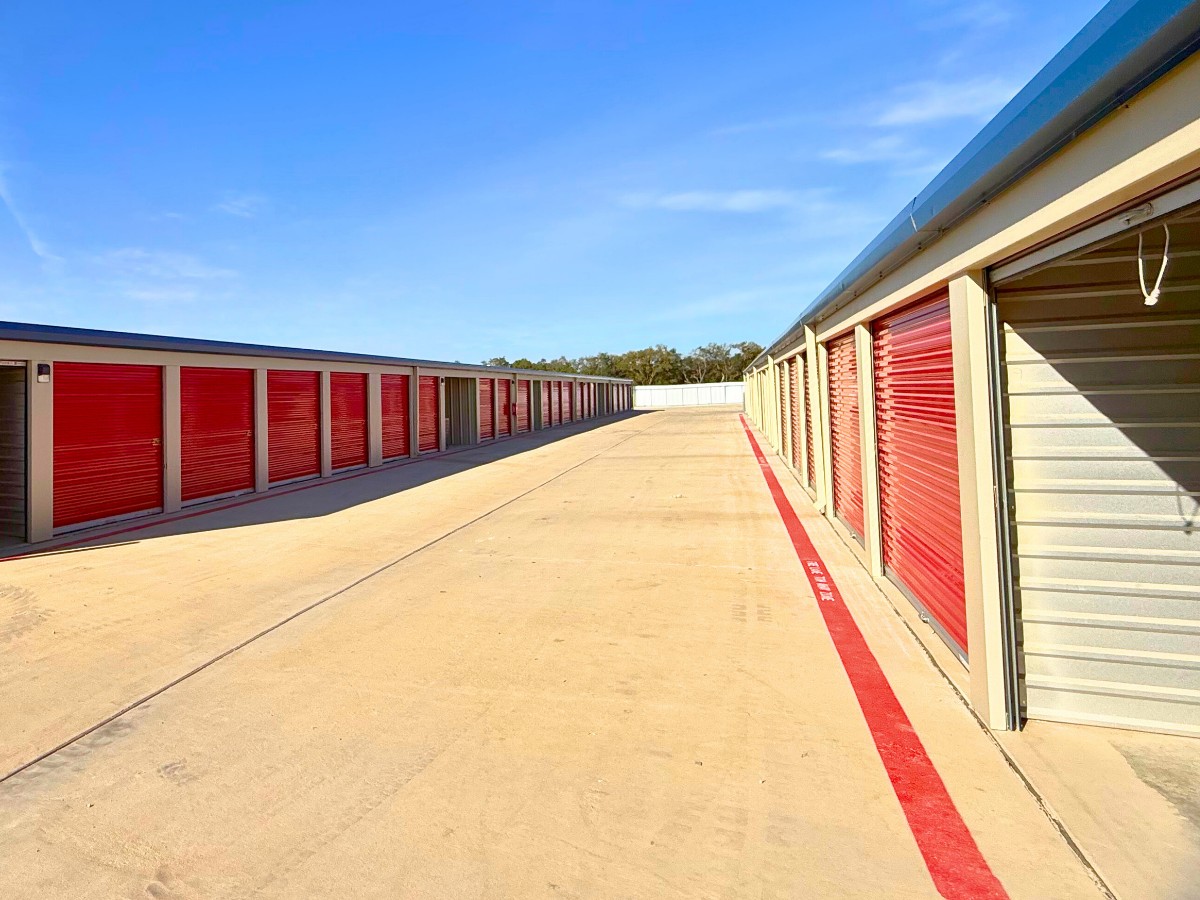 Rows of drive-up storage units with red roll-up doors and wide driveways at AAA Storage Georgetown